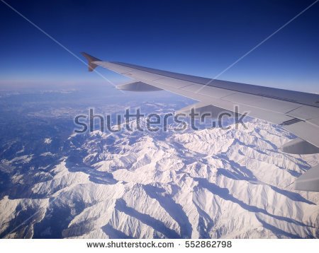 stock-photo-snow-covered-mountain-under-the-wing-of-airplane-552862798.jpg