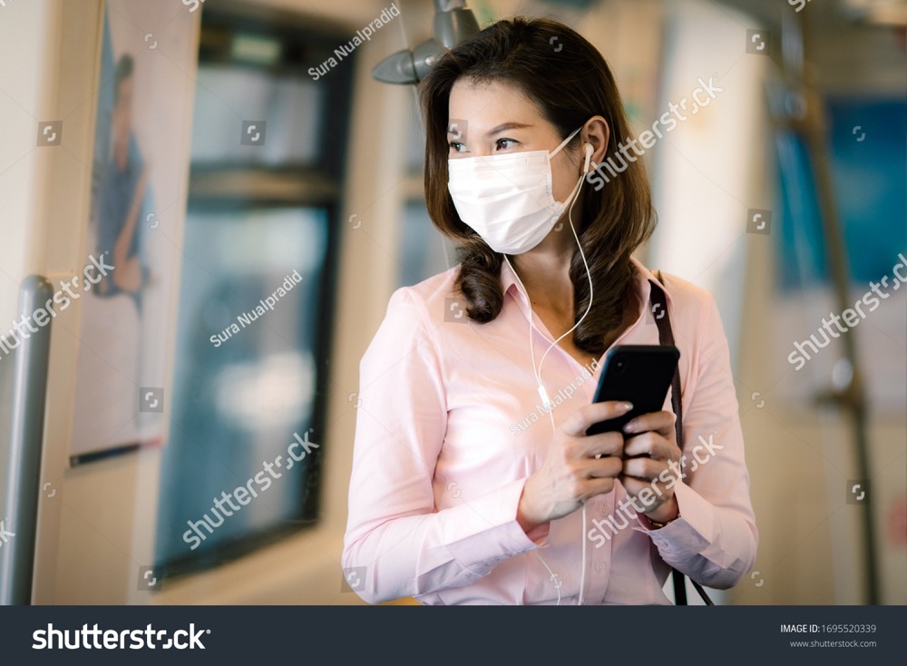 stock photo beautiful cute smiley asian businesswoman wearing protective surgical hygiene mask on face prevent 1695520339