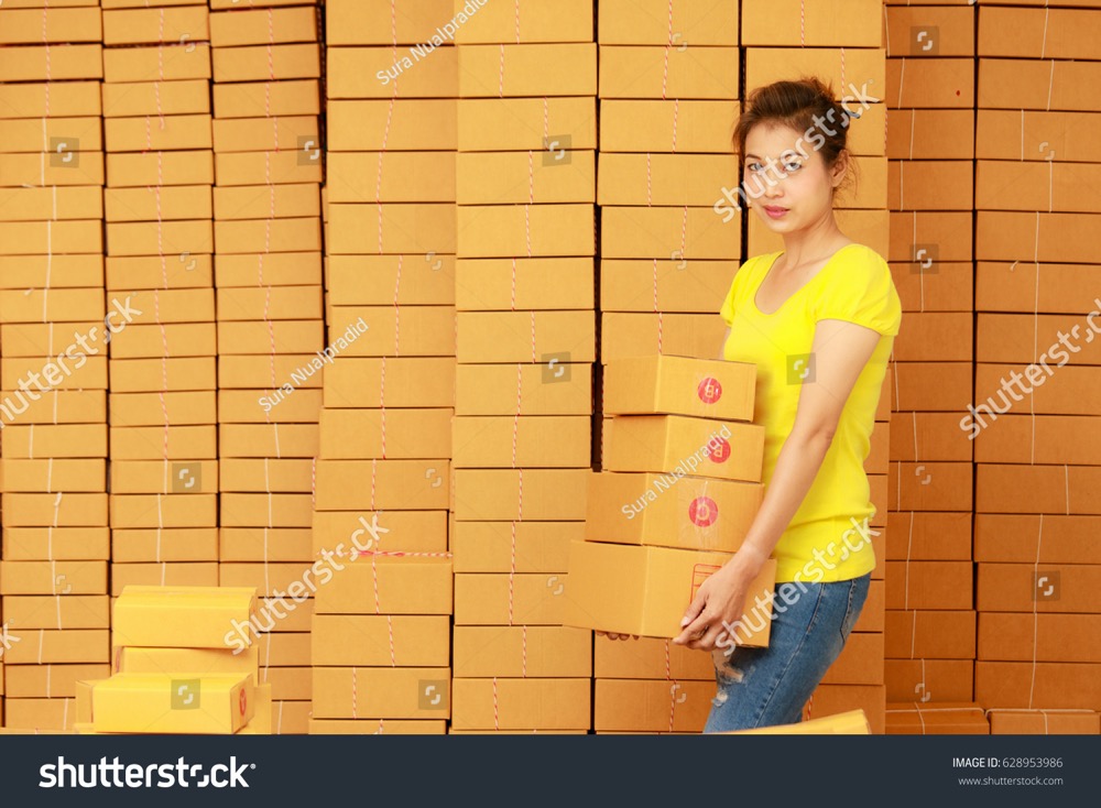 stock photo asian woman carrying parcels ready to send in online shopping business work at her home 628953986