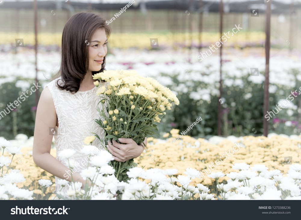 stock photo beautiful asian woman holding yellow flowers in hands with pride manner flower garden owner 1273388236